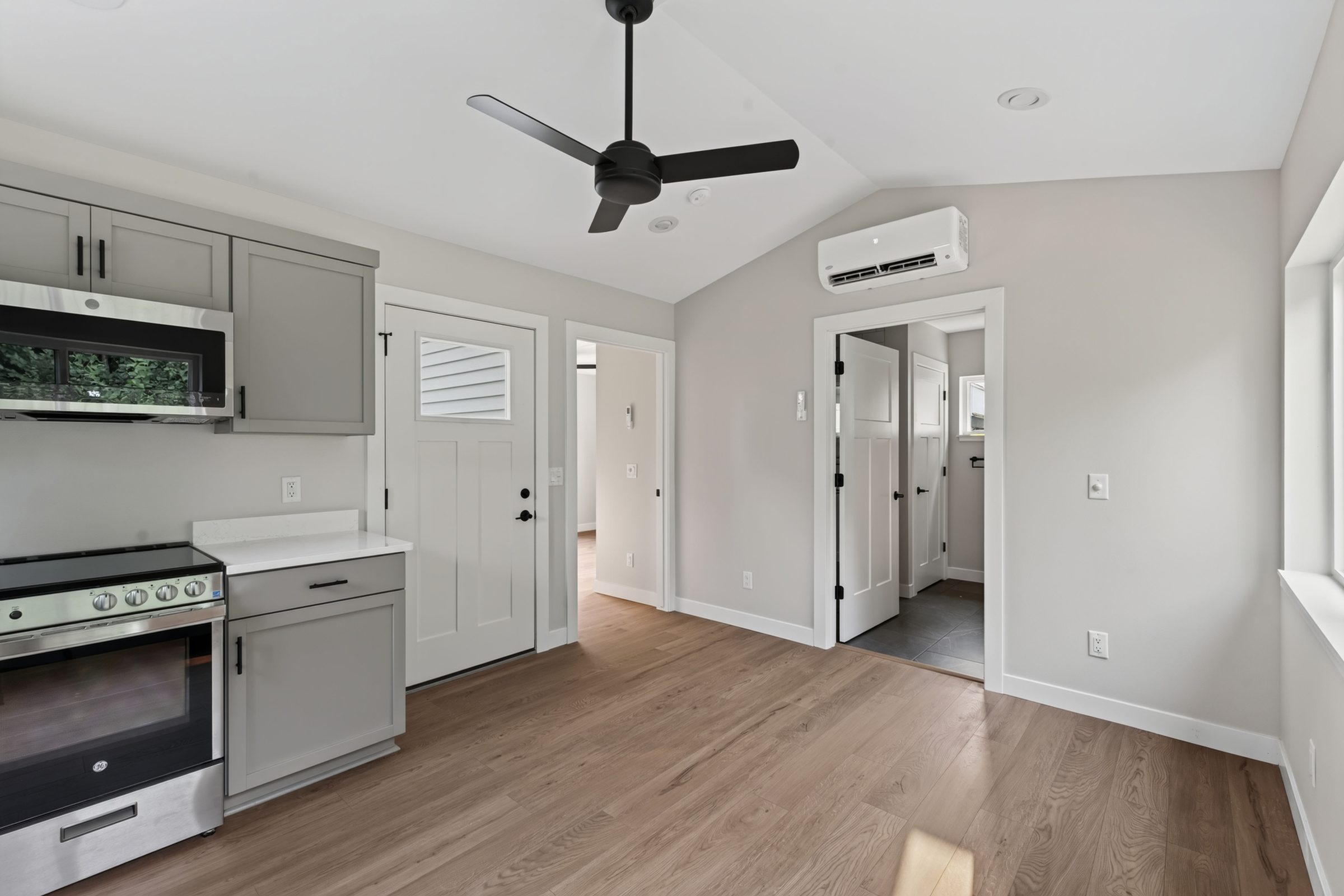 Living area looking toward the bath and laundry hall, with the mini-split overhead — aging-in-place ADU, Madison WI