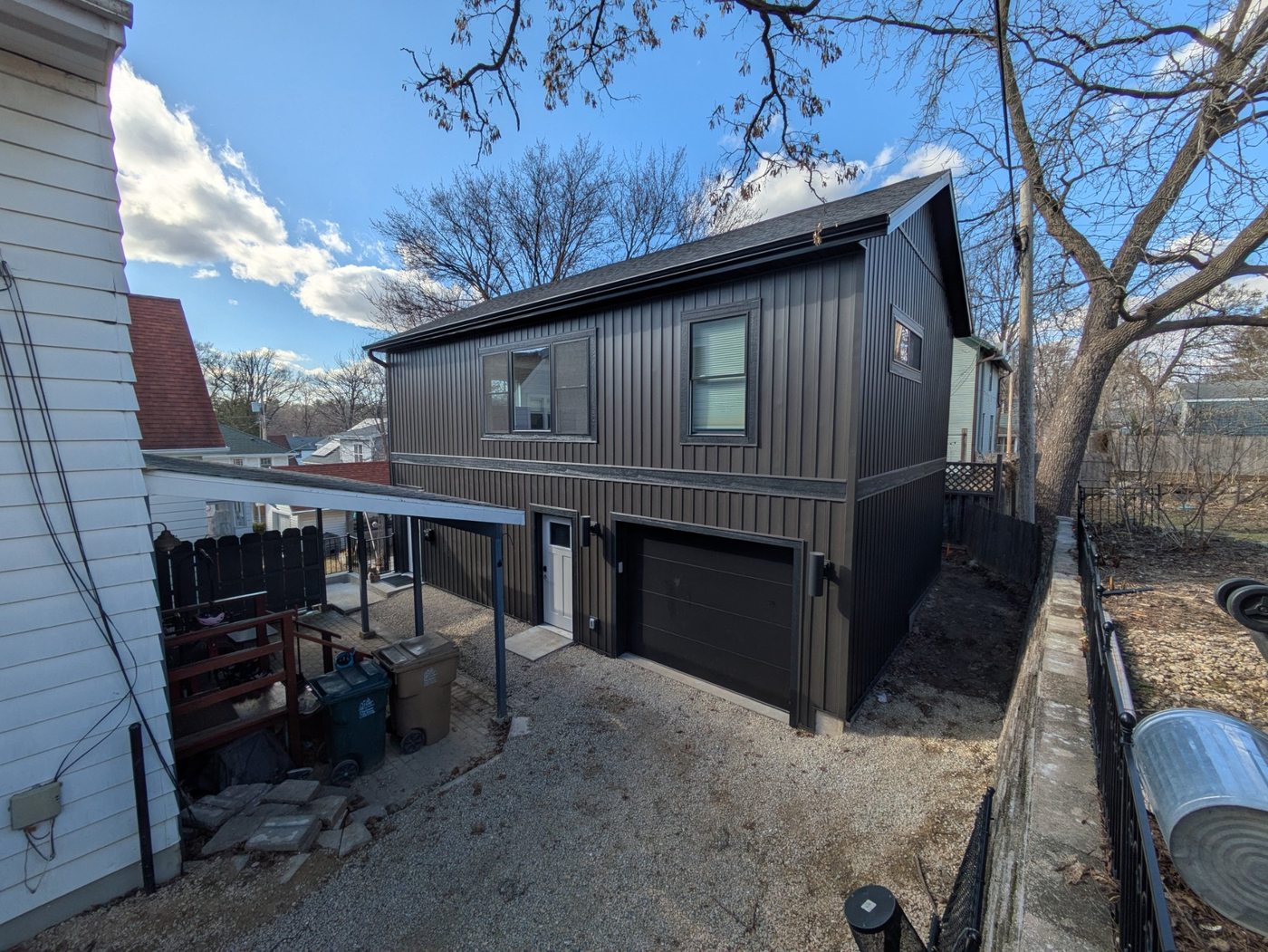 Completed two-story garage ADU full exterior — dark board and batten siding, Henry Vilas neighborhood Madison WI