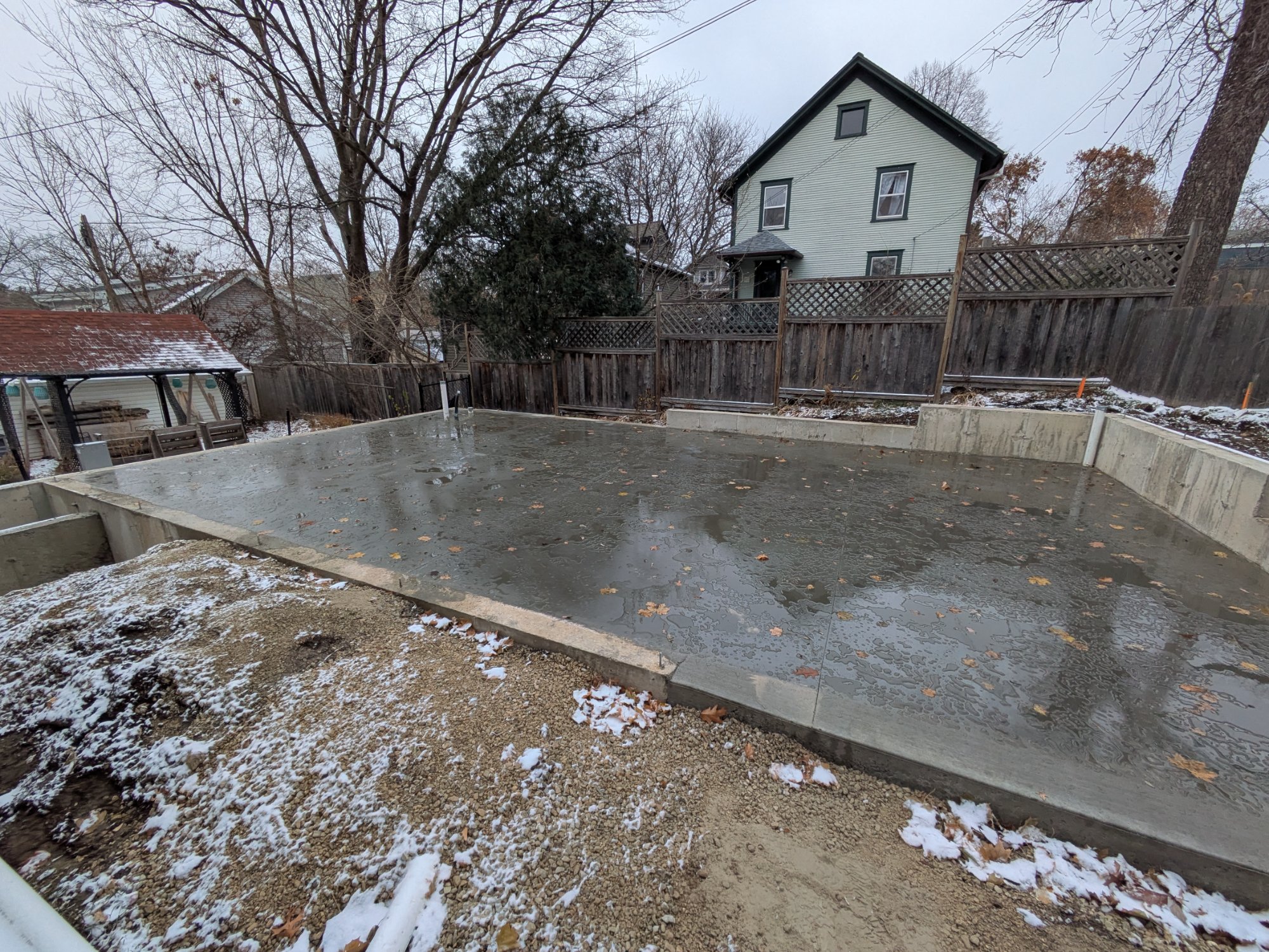 Fresh concrete slab pour for garage ADU foundation, Madison WI winter construction